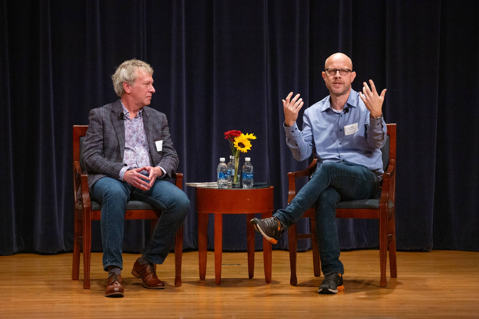 two people sitting on stage